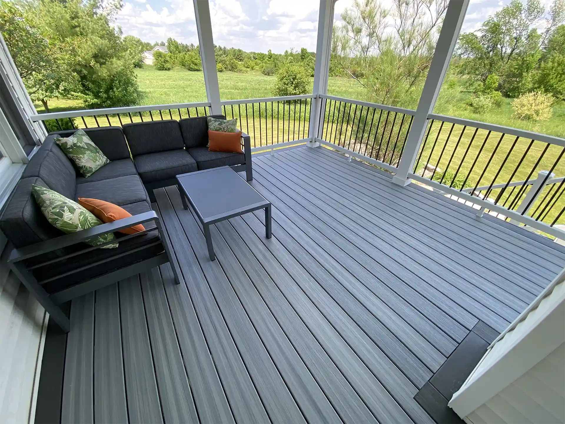 photo of a custom deck that is a screened-in and covered deck with outdoor furniture